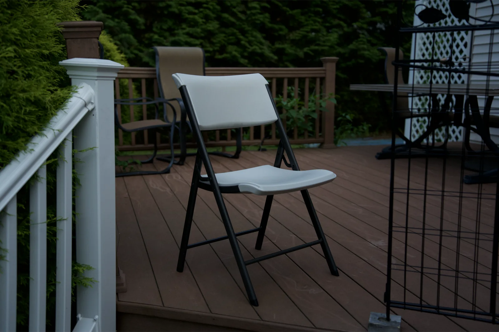 White folding chair on a wooden deck in evening light